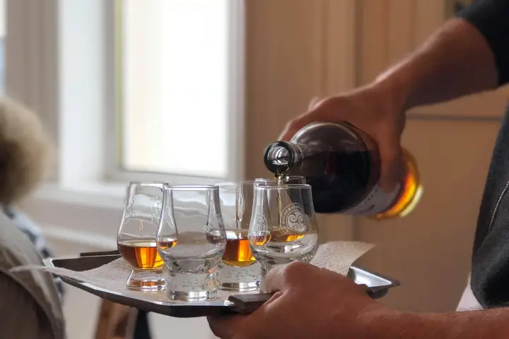 waiter putting whiskey in glasses