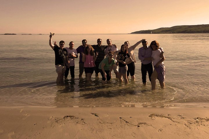 people posing for the picture at the beach