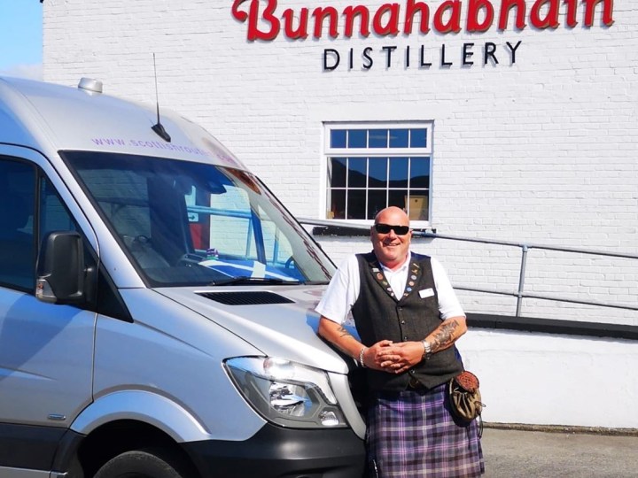 a person standing in front of a car posing for the camera