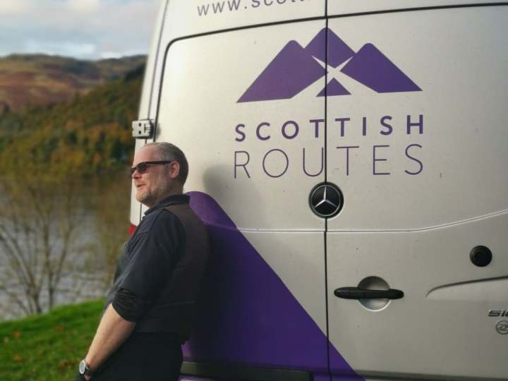 a person holding a sign posing for the camera