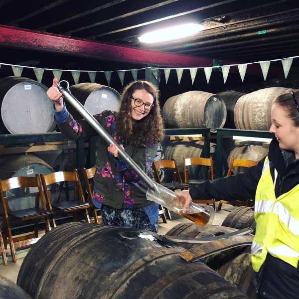 a group of people standing in front of a barrel