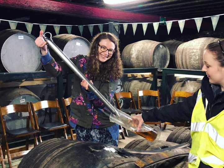 a group of people standing in front of a barrel