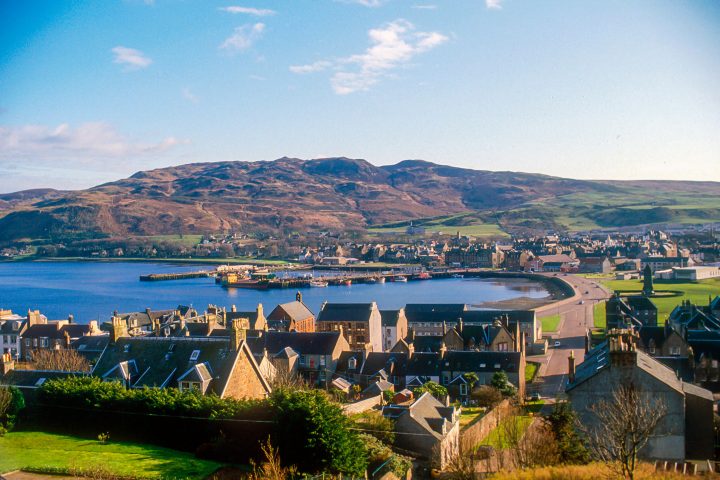 a bridge over a body of water with a mountain in the background