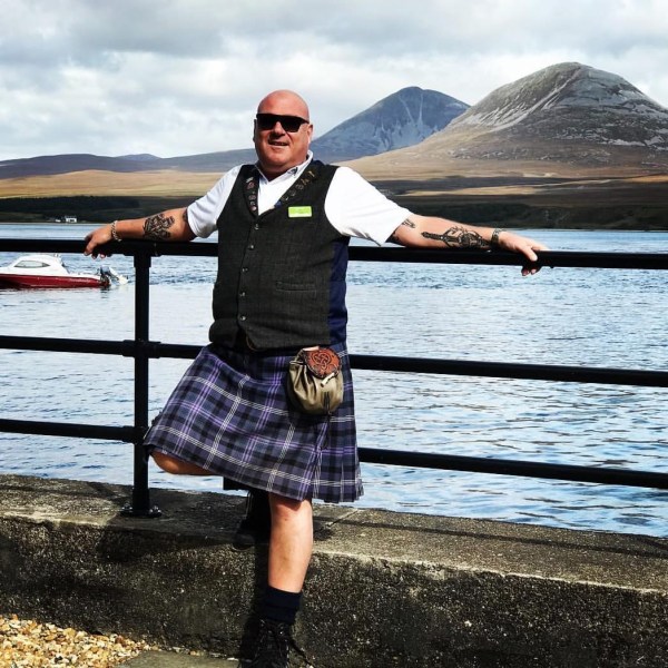 a man and a woman standing in front of a lake